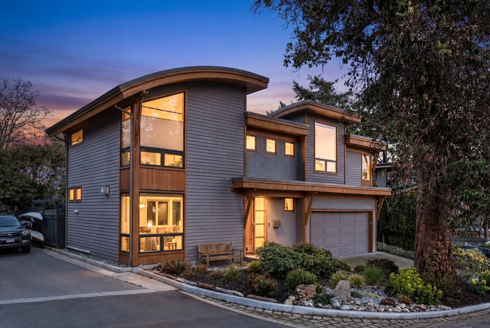 220 Moss Rock Place at dusk — curved roof architecture lit from within